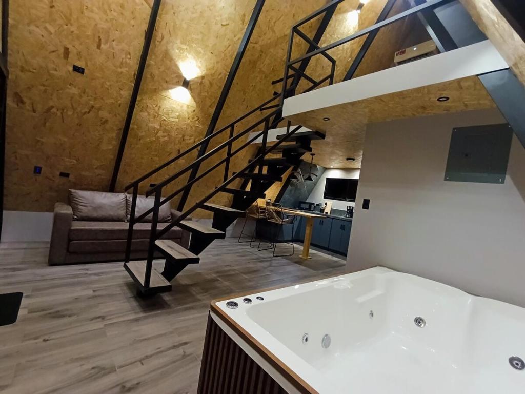 a bathroom with a bath tub and a staircase at Zerenity Views - 40 minutes from La Fortuna! 