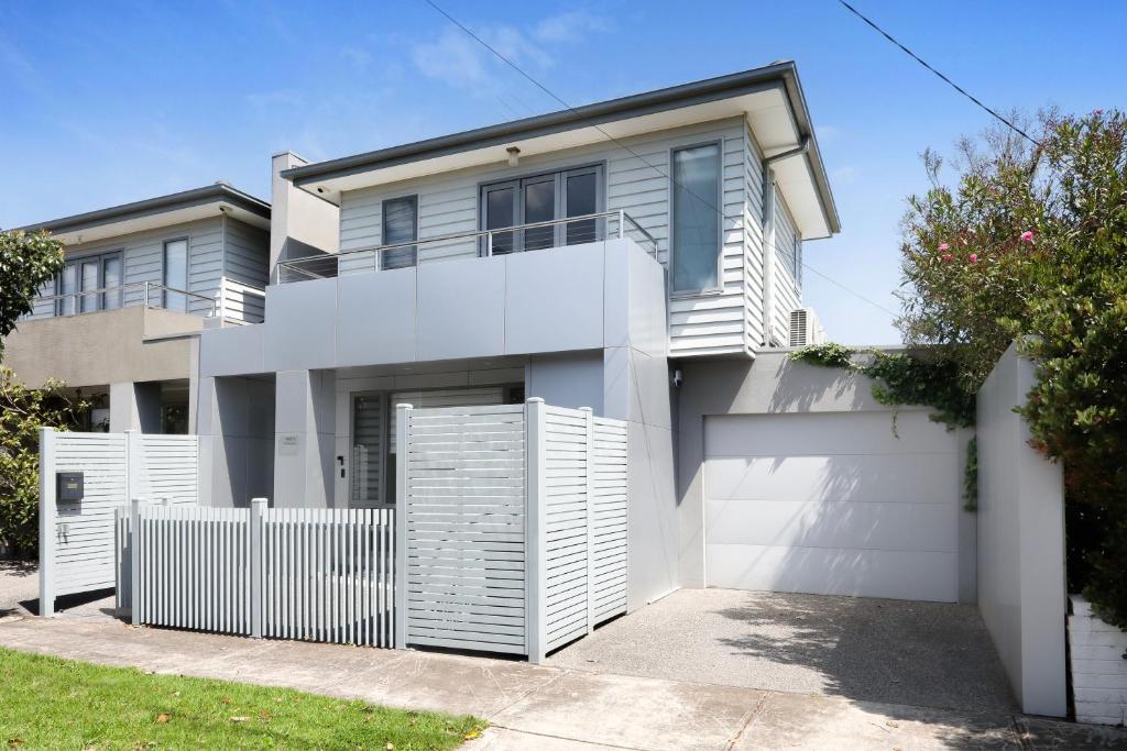 a house with a white fence in front of it at Home Away From Home - Maribyrnong Boutique Townhouse in Maribyrnong
