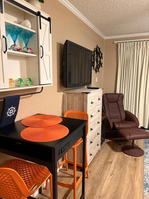 a room with a desk with chairs and a tv at Seawall Breeze One bedroom Condo in Galveston in Galveston