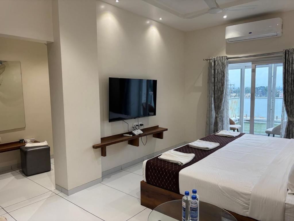 TuljapurThe Skyland Hotel And Restaurant的一间配有床和平板电视的酒店房间