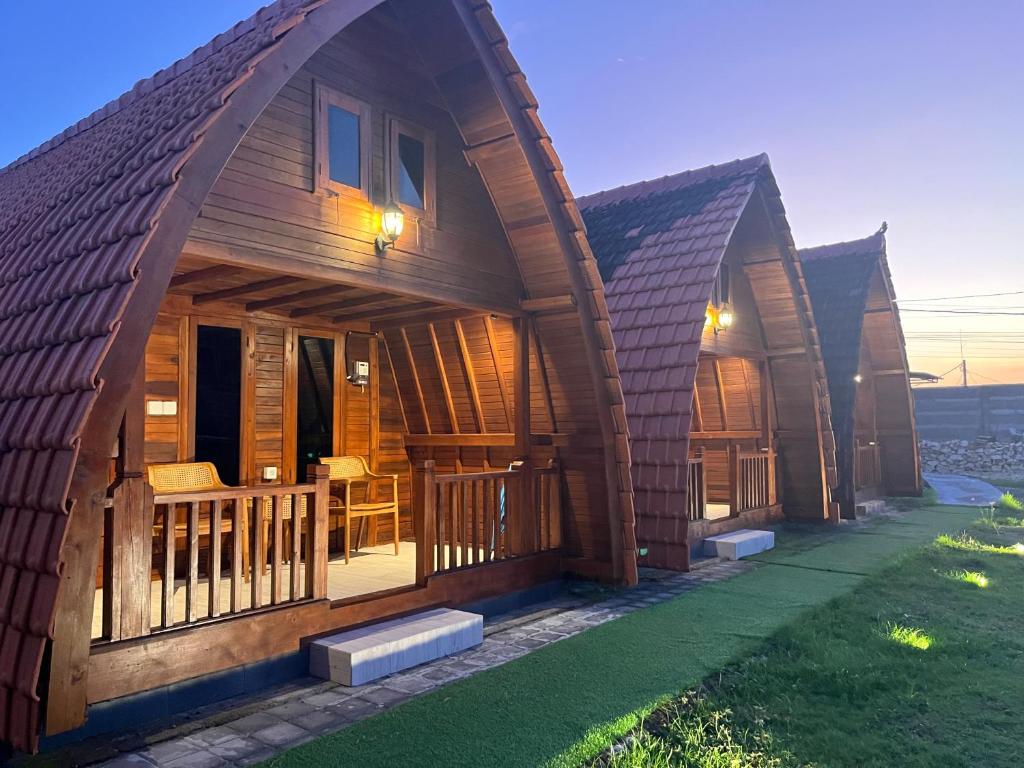 a group of cottages with a large roof at Villa Aiden Bungalow 2 near Beach in Ungasan