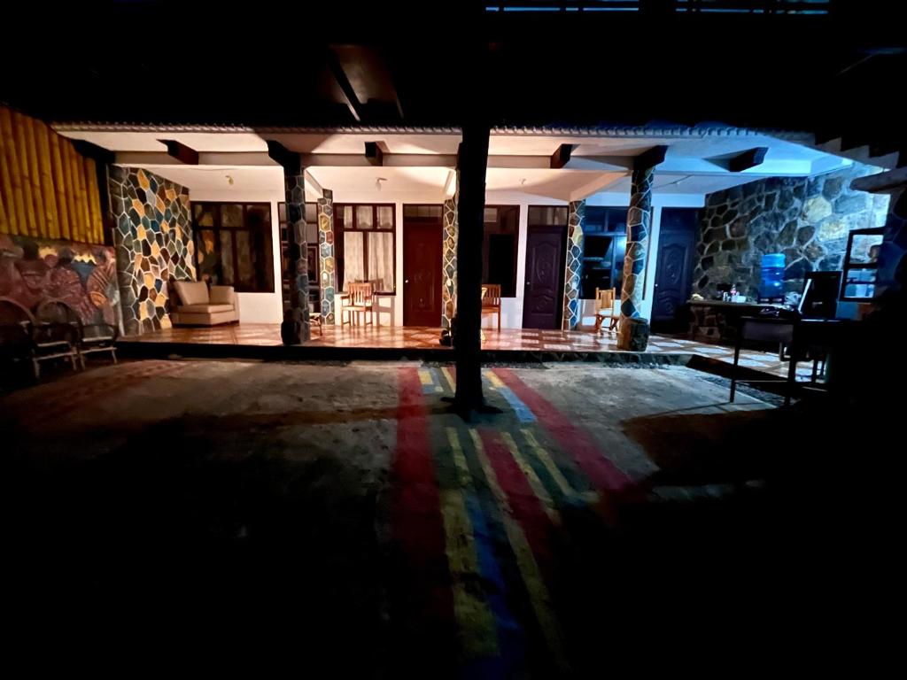 una stanza buia con un tavolo e delle sedie in un edificio di Mandalas Hideout a San Pedro La Laguna