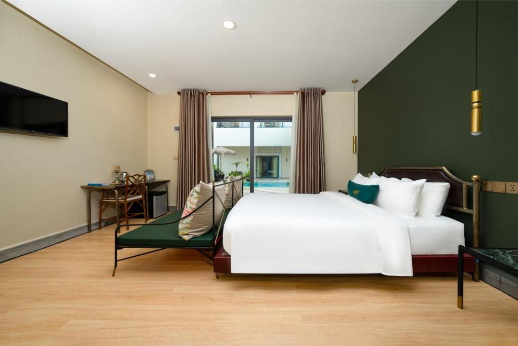 Un dormitorio con una cama blanca grande y una ventana en Vrest Hotel Otres Beach, en Sihanoukville