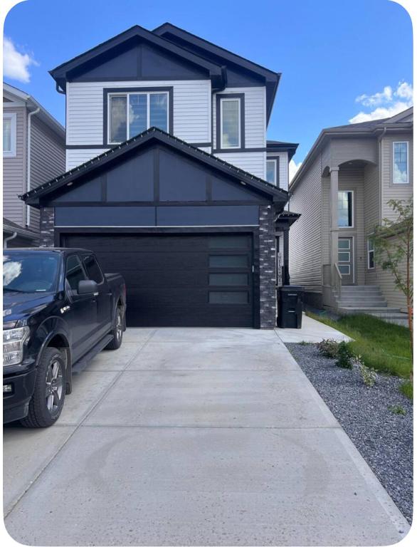 a car parked in front of a black garage at Private room in Basement suite in Edmonton