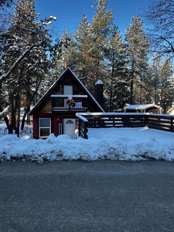 a house with a fence in the snow at Snuggle Inn Cabin in Running Springs