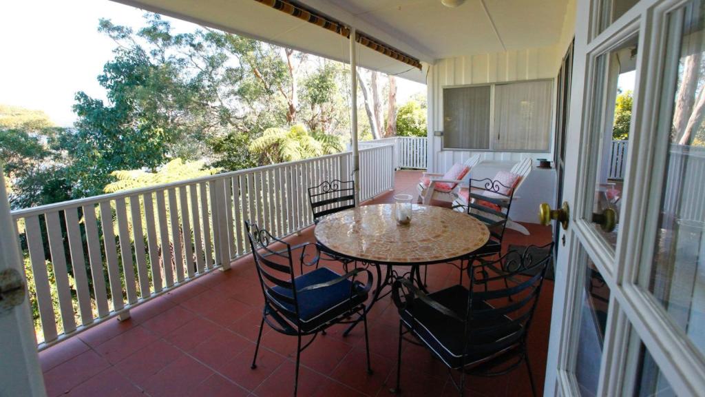 un patio con tavolo e sedie su un balcone di Lakehouse Akolele 19 Flower Circuit- Wallaga Lake Bermagui a Central Tilba