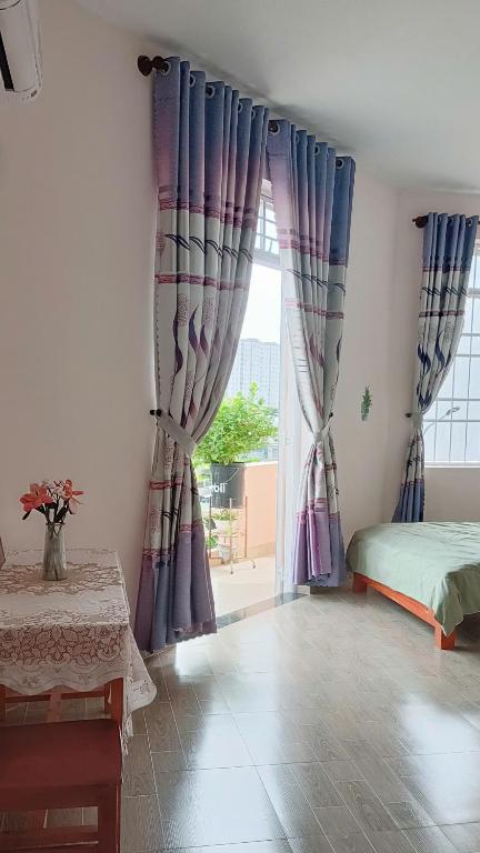 a bedroom with curtains and a bed and a window at Thuy's homestay in Vung Tau