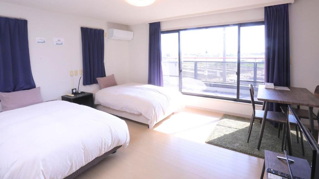 Una cama o camas en una habitación de ゲストハウスガーデンズmihama