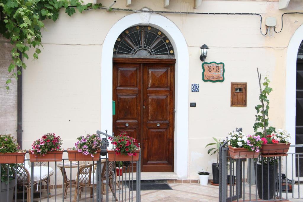 a door to a building with tables and chairs and flowers at L'incanto del mare in Acciaroli