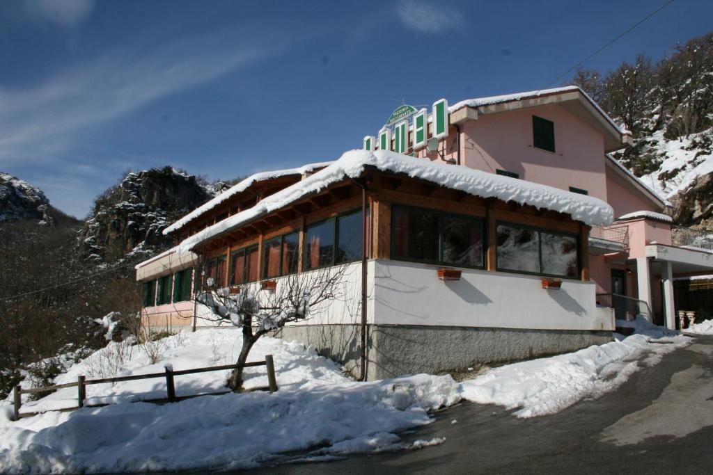 um edifício com neve no chão à sua frente em Hotel Nido delle Rondini em Fallo