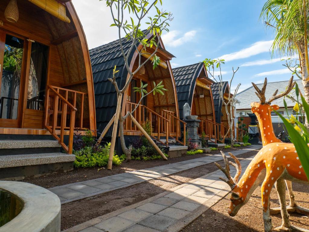MantaakLumbung Lodge Lovina的前面有鹿雕像的房子