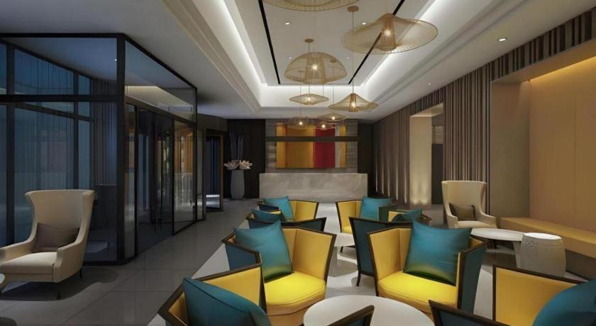 a lobby with yellow and blue chairs and tables at Jinjiang Inn Select Xixian New Distict Century Avenue in Xianyang