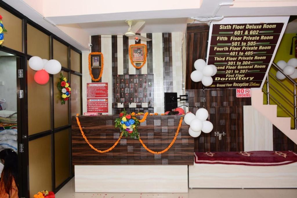Un restaurante con un mostrador con un cartel y globos. en Royal Kashi Lodge, en Prayagraj