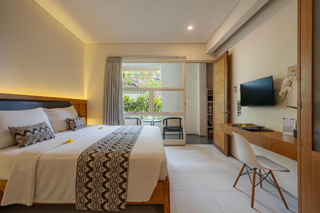 a hotel room with a bed and a television at Bali True Living in Denpasar