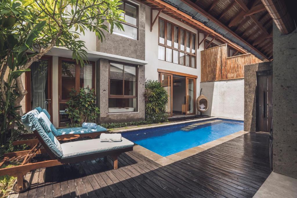 a house with a swimming pool in the backyard at Teratai Villa Canggu by Ini Vie Hospitality in Canggu