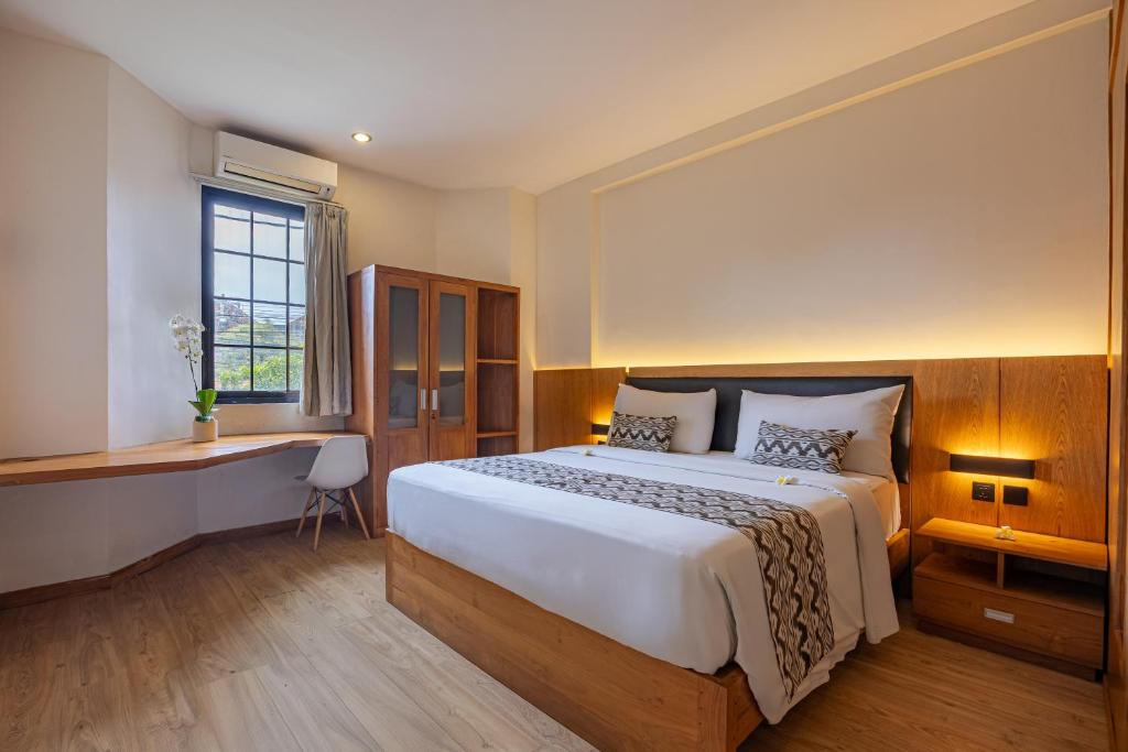 a bedroom with a large bed and a desk at Bali True Living in Denpasar