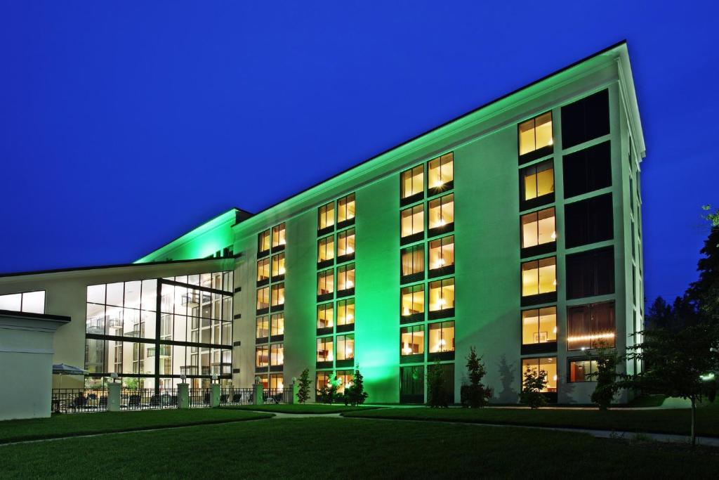 un gran edificio verde con luces encendidas por la noche en Holiday Inn Asheville - Biltmore West by IHG, en Asheville
