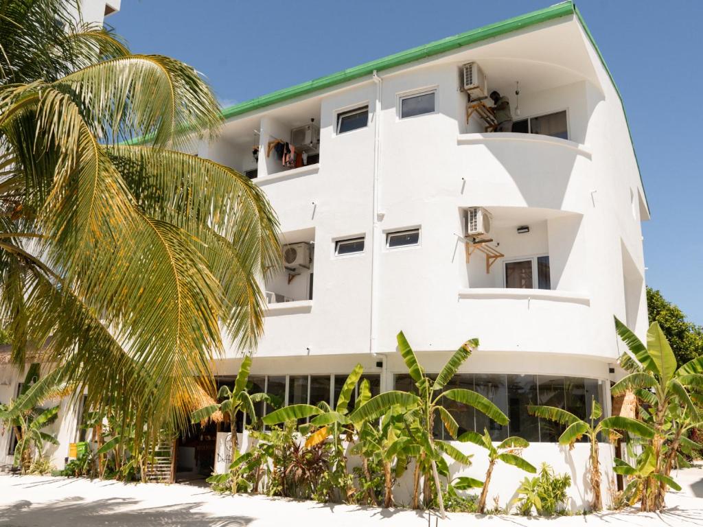 a white building with people on the balconies at Dhiffushi Inn in Dhiffushi