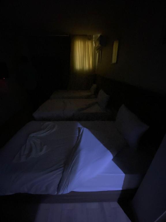 开罗Pyramids Fort & free pickup shuttle的蓝色光线的深色客房内的两张床