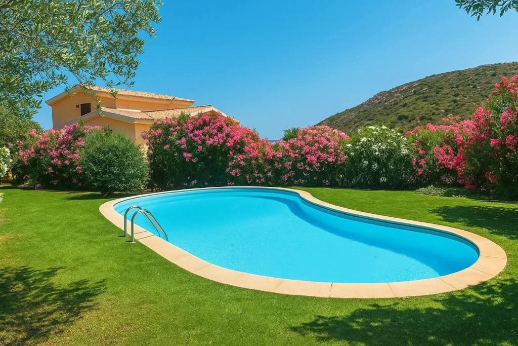 a swimming pool in a yard with flowers at Villino Tiriddò Porto San Paolo in Porto San Paolo