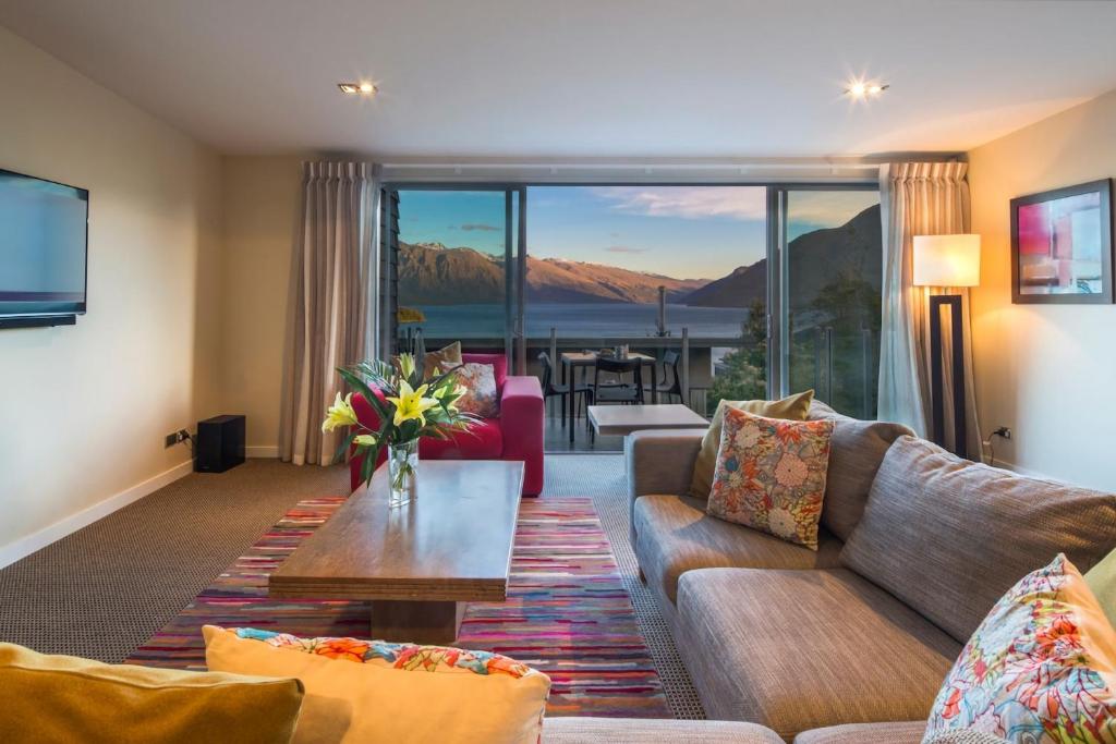 a living room with a couch and a table at LakeRidge Queenstown by Staysouth in Queenstown