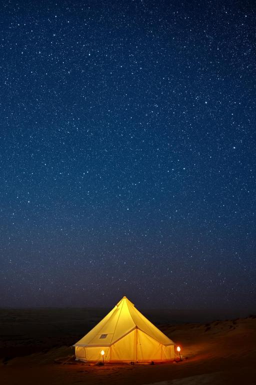 a tent in the desert under a night sky at Night Stars Camp in Badīyah