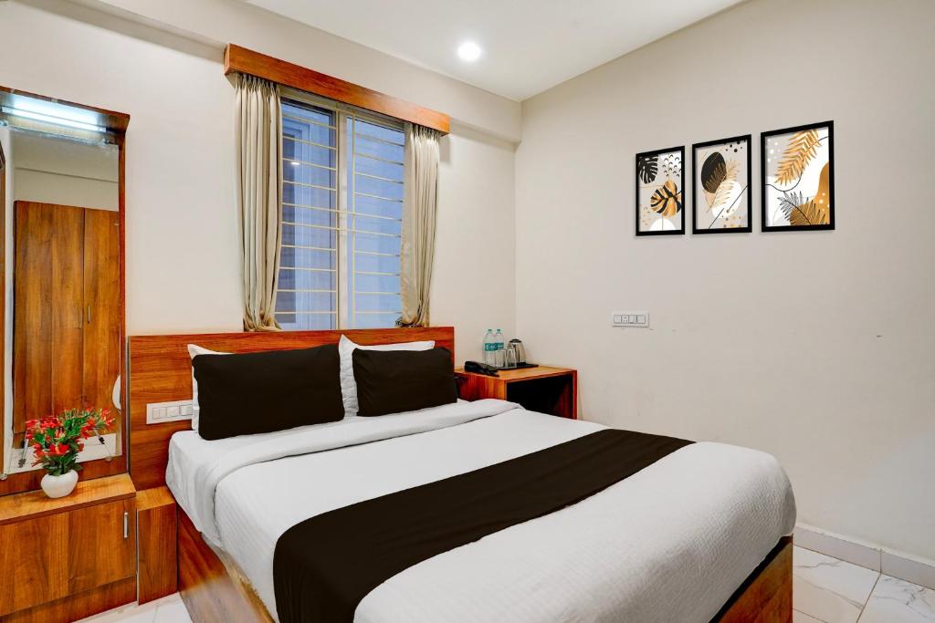 um quarto com uma cama grande e uma janela em Super Townhouse Marathahalli KLM Fashion Mall Formerly Hotel Avenue em Bangalore