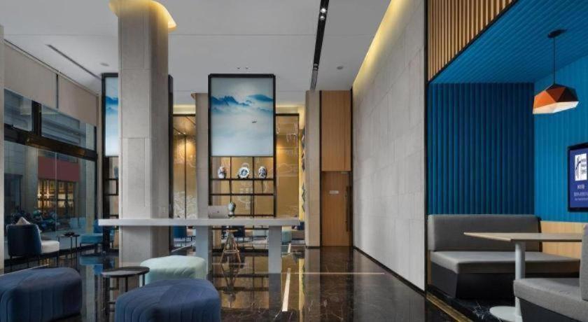 a lobby with chairs and tables in a building at Holiday Inn Express Jingdezhen City Center By IHG in Xianghu