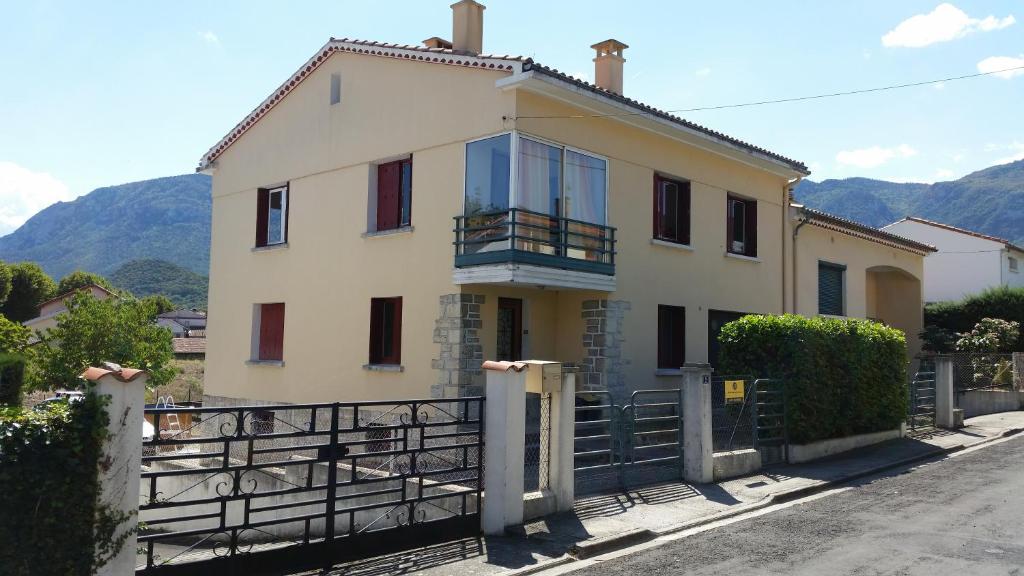 a large white house with a balcony on a street at Quillan La Vue - Chambres d'hôtes in Quillan