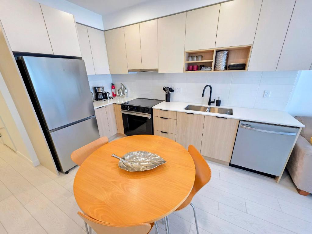 a kitchen with a wooden table and a refrigerator at 2 bedroom heart of Central Surrey in Surrey