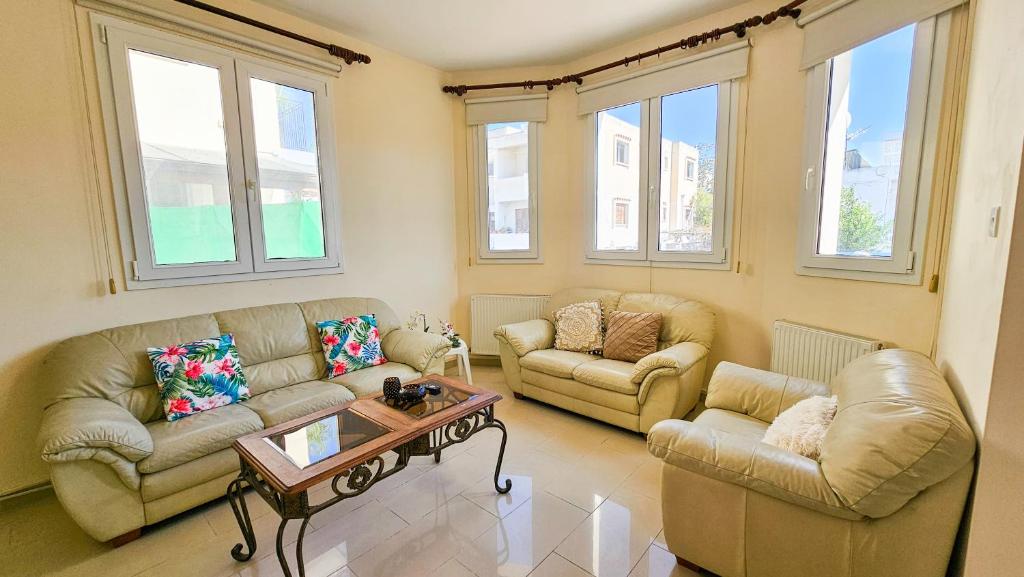 a living room with two couches and a coffee table at Townbeach Villa with Private Pool in Voroklini