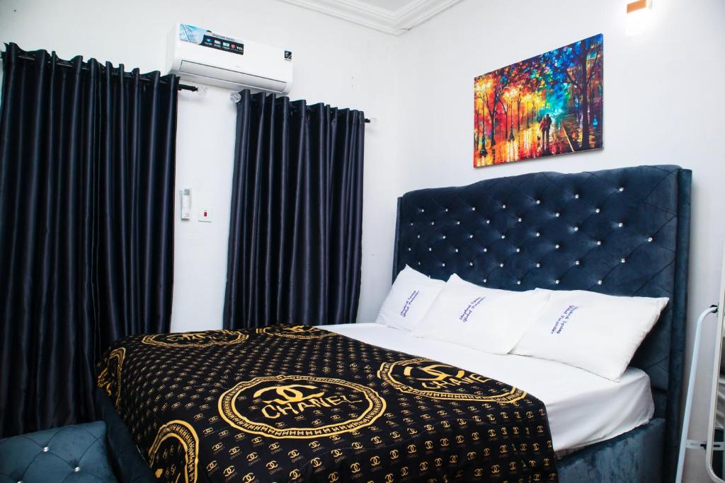 a bedroom with a bed with a black head board at Shepherd Spring Apartments in Gbogije