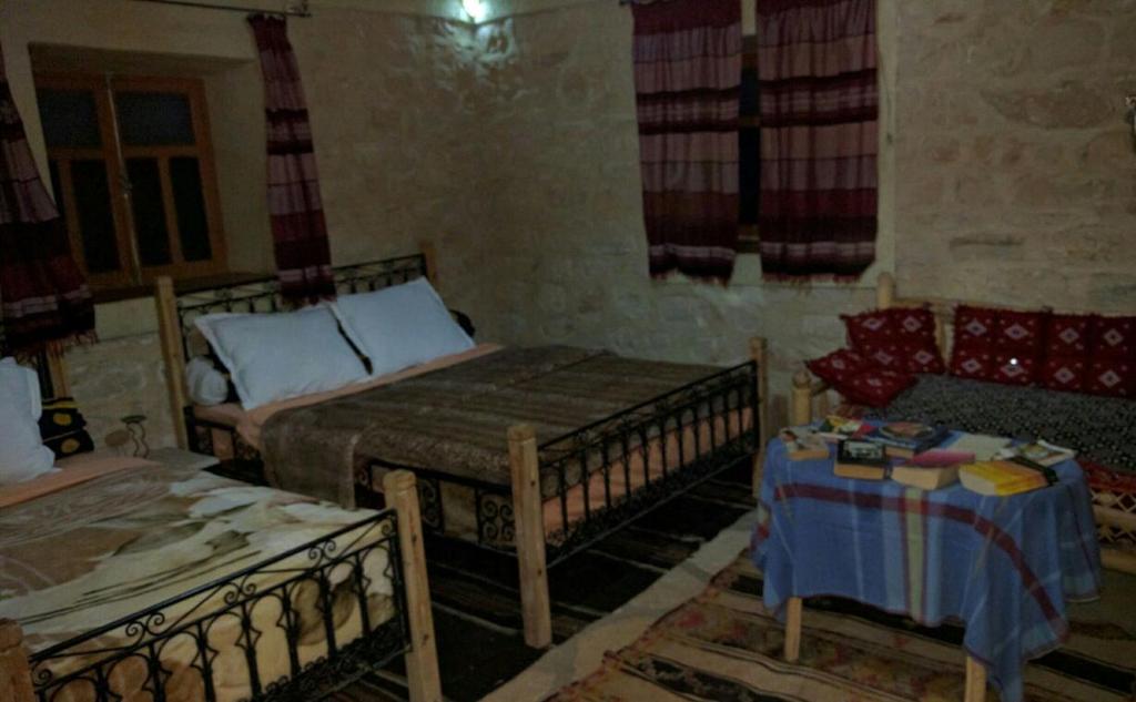 ein Zimmer mit 2 Betten und einem Sofa darin in der Unterkunft Kasbah Dar Talouste in Afela nʼIsly