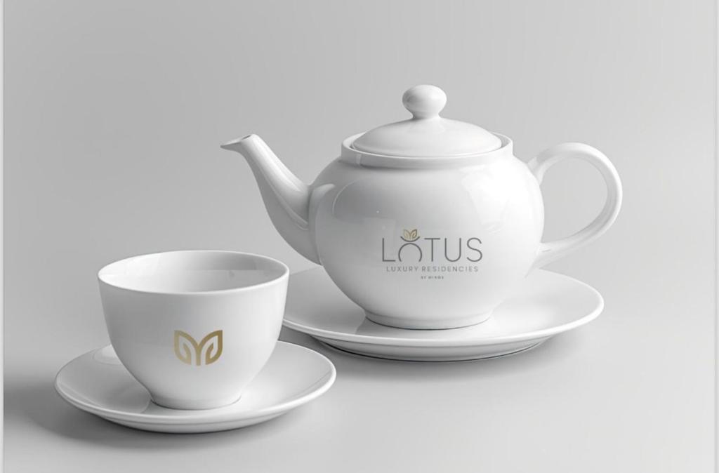 eine Teekanne und zwei Untertassen mit einer Teetasse in der Unterkunft Lotus Luxury Residencies in Negombo