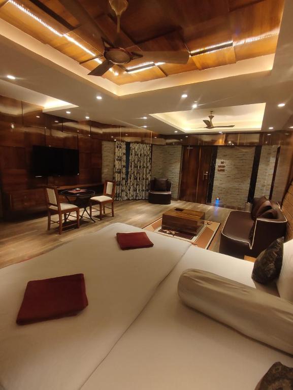 a bedroom with a large bed and a living room at Krishti Resorts in Tajpur