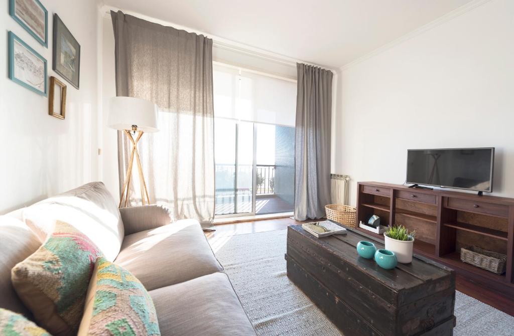 Una sala de estar con un sofá y un televisor. en LovelyStay - Porto Beach Apartment, en Oporto