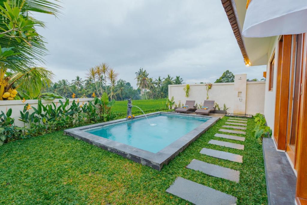 a swimming pool in the yard of a house at Griya Mandara Ubud Villa in Ubud