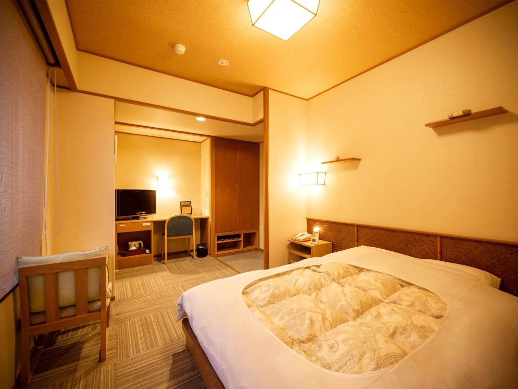 鹤冈市Yunohama Onsen TATSUNOYU的一间带大床和电视的卧室