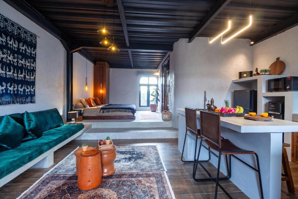 a living room with a green couch and a kitchen at Warehouse Loft - Chic industrial aesthetic loft in Dalung