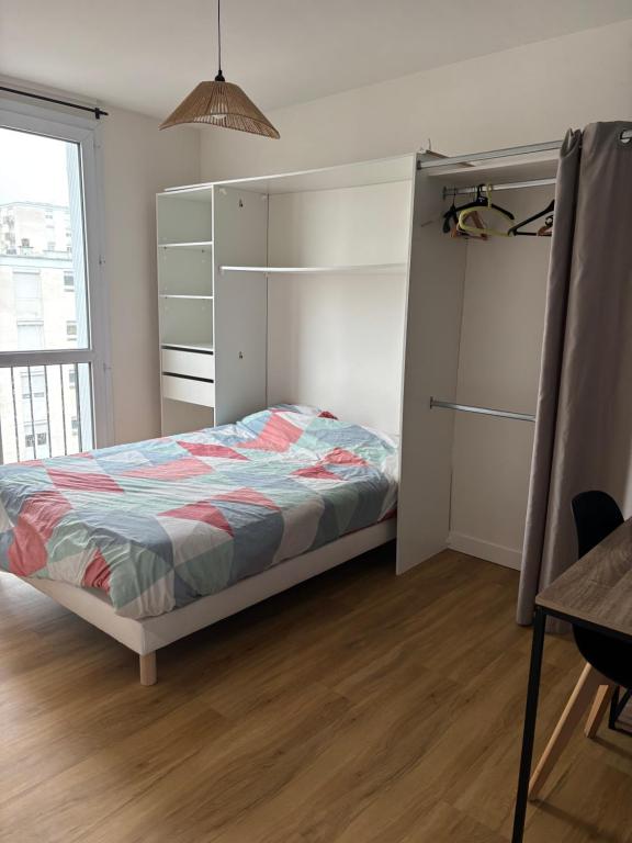 una camera da letto con un letto e una grande finestra di Spacieux T4 lumineux avec balcon confort, calme et modernité à Joué-lès-Tours a Joué-lés-Tours