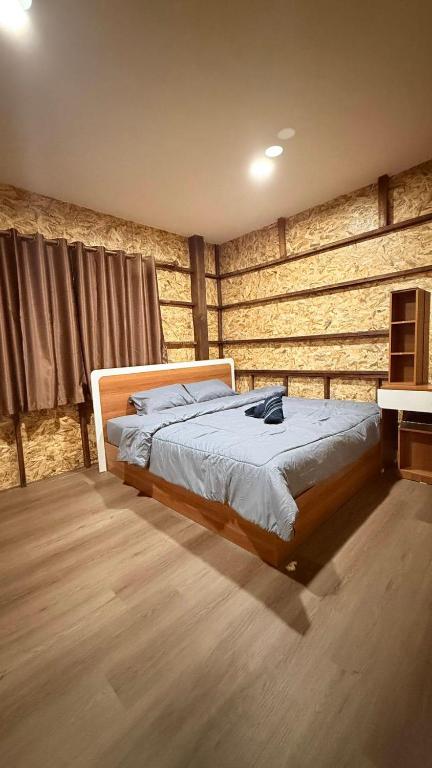 een slaapkamer met een bed en een houten wand bij Baan Chok Dee Homestay in Chiang Khan