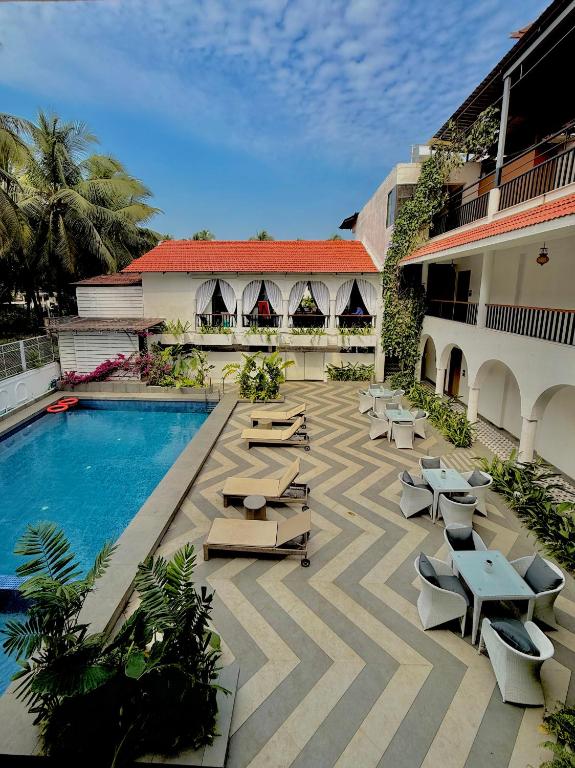 a courtyard with lounge chairs and a swimming pool at Bougainvillea in Nagaon