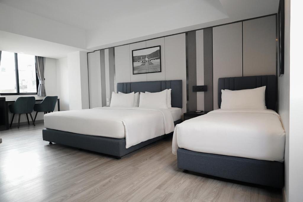 A twin-bed room with a dining-style corner beside the window.