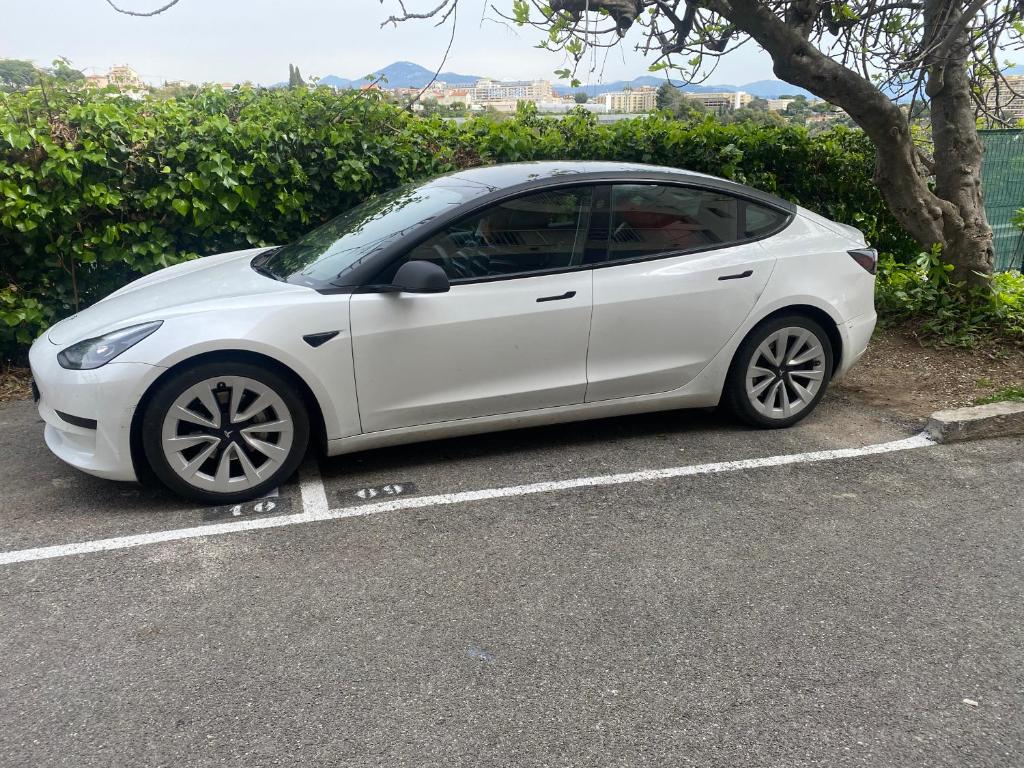 un coche blanco aparcado en un estacionamiento en Studio Jardin Fleuris Parking, en Niza