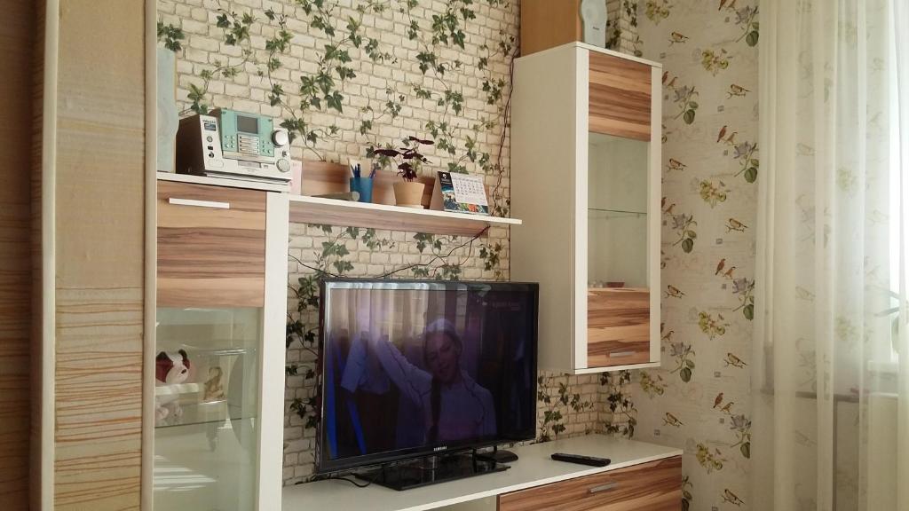 telewizor siedzący na ladzie w pokoju w obiekcie Sunny Apartment w Rydze