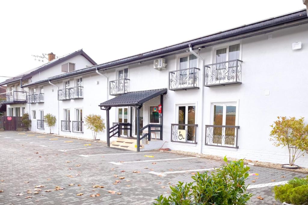 eine Reihe weißer Gebäude mit Balkonen in der Unterkunft Pensiunea Vila Chesa in Corunca