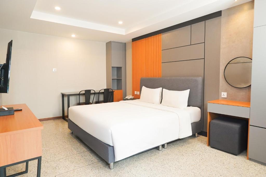 A bedroom with a large bed, two-person table and compact dressing area.