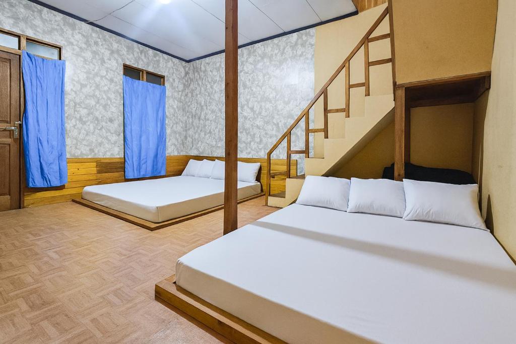 um quarto com 2 camas e uma escada em Villa TB Pangalengan Bandung RedPartner em Palayangan