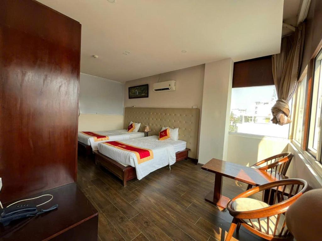 Khách sạn Anh Đức 1 في Ga Phú Văn: غرفة فندق بها سريران وطاولة