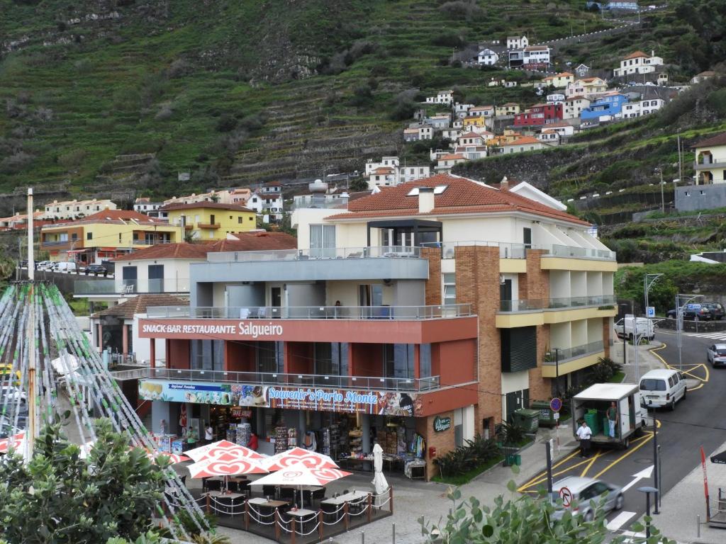 莫尼兹港Hotel Salgueiro的城市街道上的一栋建筑，旁边是一座山